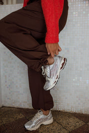 Pantalon cargo à poches latérales porté par une femme, vue rapprochée, baskets, jambes