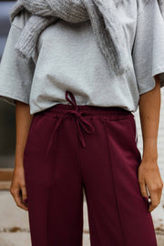 Pantalon à bandes latérales porté par une femme, vue rapprochée, cordon de serrage, taille