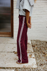 Pantalon à bandes latérales porté par une femme, vue de profil, bande latérale blanche