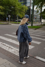 Veste polaire à carreaux portée par une femme, en marchant, vue de dos