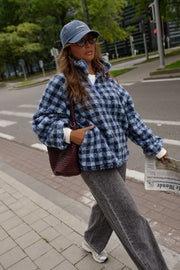Veste polaire à carreaux portée par une femme, silhouette entière, sac à l'épaule