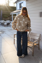Veste polaire à cœurs portée par une femme, vue de face, terrasse, jean large