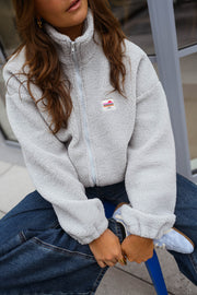 Veste polaire zippée chaude portée par une femme, vue rapprochée, col zippé, jean foncé