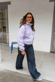 Veste polaire rayée zippée portée par une femme, en marchant, véranda, jean large