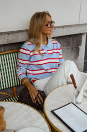 Polo rayé col boutonné porté par une femme, assise, terrasse, regard de côté