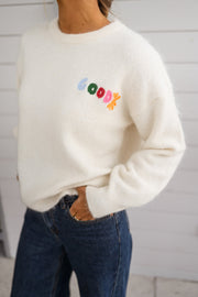 Pull doux et chaud porté par une femme, vue rapprochée, logo coloré, jean