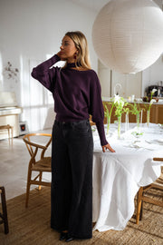 Pull à épaule dénudée prune porté par une femme, vue de dos, salle à manger, jean large