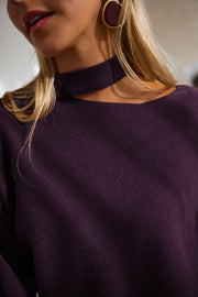 Pull à épaule dénudée prune porté par une femme, vue rapprochée, épaule dénudée, boucle d'oreille