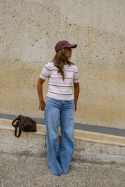 Pull en maille légère porté par une femme, silhouette entière, casquette, sac marron
