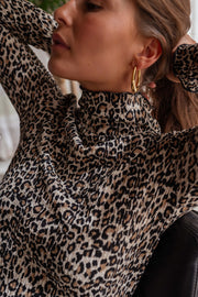 Pull léopard à col montant porté par une femme, vue rapprochée, col montant, boucle d'oreille