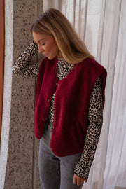 Pull léopard à col montant porté par une femme, vue de face, gilet bordeaux, rideaux