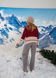Pull ample col rond porté par une femme, vue de trois-quarts, bonnet gris, pantalon gris