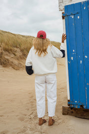 Pull loose à col polo porté par une femme, vue de dos, casquette rouge