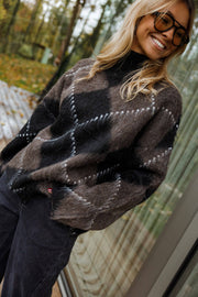 Pull jacquard col montant porté par une femme, vue rapprochée, losanges, lunettes de soleil