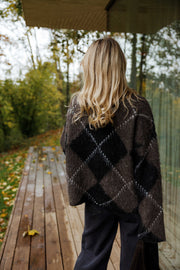 Pull jacquard col montant porté par une femme, vue de dos, terrasse en bois, cheveux blonds