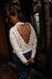 Pull à dos ouvert fleuri écru porté par une femme, vue de dos, dos ouvert, forêt