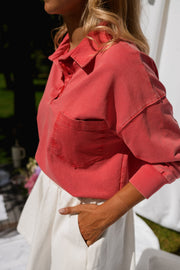 Pull délavé col boutonné porté par une femme, vue rapprochée, de côté, jupe blanche