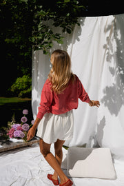 Pull délavé col boutonné porté par une femme, en marchant, chaussures rouges