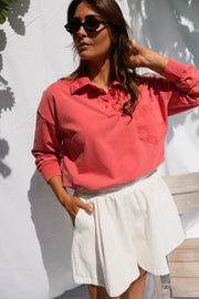 Pull délavé col boutonné porté par une femme, vue rapprochée, lunettes de soleil, mains dans les poches