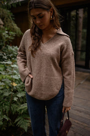Pull doux col V loose beige porté par une femme, vue rapprochée, col V, sac à main