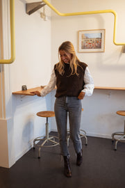 Pull sans manches effet mouton chocolat porté par une femme, vue de face, bar, jean