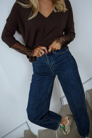 Pull doux à manches longues marron porté par une femme, vue rapprochée, manches en dentelle, jean foncé