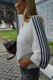 Pull à bandes manches trois-quarts porté par une femme, vue de profil, manche à bandes, sac marron