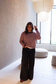 Pull rayé effet cachemire porté par une femme, vue de face, salon, pantalon noir