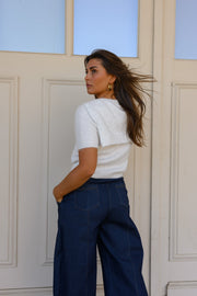 Pull à revers amovible porté par une femme, vue de trois-quarts, de dos, pantalon bleu marine