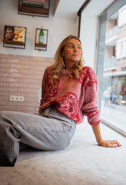 Pull doux à paillettes framboise porté par une femme, assise, banc, jean