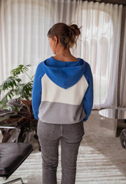 Pull doux à capuche bleu porté par une femme, vue de dos, capuche, queue de cheval