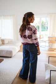 Pull à fleurs col rond porté par une femme, vue de dos, salon, jean large