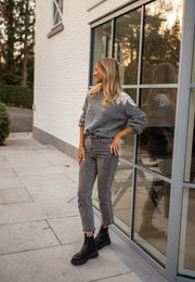 Pull à perles col rond gris porté par une femme, silhouette entière, bottines noires, jean gris