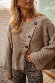 Pull boutonné col rond taupe porté par une femme, vue rapprochée, boutons, manches larges