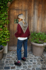 Pull ample doux col rond bordeaux porté par une femme, vue de dos, plantes, écharpe grise