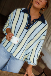 Pull ample à col boutonné bleu clair et crème à rayures porté par une femme, vue rapprochée, penchée en avant