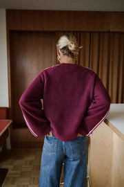 Pull à manches rayées évasées porté par une femme, vue de dos, cheveux attachés