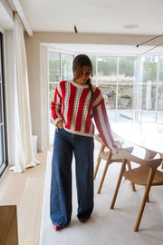 Pull ajouré à col rond porté par une femme, vue de face, véranda, table