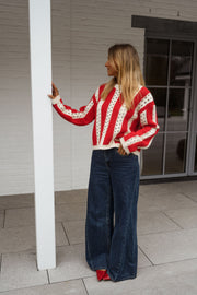 Pull ajouré à col rond porté par une femme, vue de dos, poteau blanc, jean large