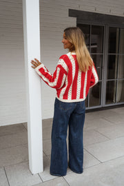 Pull ajouré à col rond porté par une femme, vue de dos, poteau, cheveux blonds