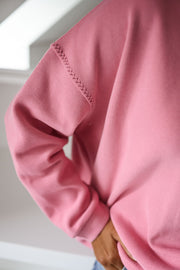 Pull loose à col rond porté par une femme, vue rapprochée, manche, surpiûres