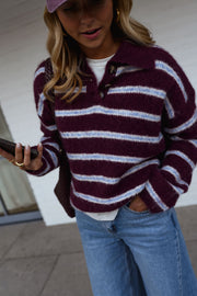 Pull doux à col revers porté par une femme, vue rapprochée, rayures bordeaux, téléphone
