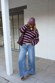 Pull doux à col revers porté par une femme, vue de trois-quarts, casquette mauve, sac marron