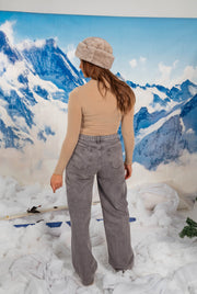 Sous-pull moulant à manches longues beige porté par une femme, vue de dos, bonnet gris, jean gris