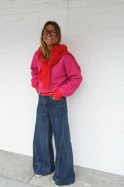 Pull à bords contrastés porté par une femme, vue de face, foulard rouge, jean foncé