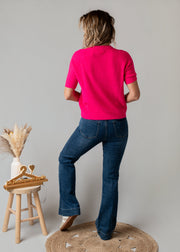 Pull baby alpaga manches courtes porté par une femme, vue de dos, jean flare, tabouret
