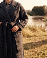 Manteau oversize en laine porté par une femme, vue de trois-quarts, rivière, manteau ouvert