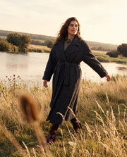 Manteau oversize en laine porté par une femme, vue de trois-quarts, ceinture, herbes