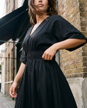 Robe midi évasée en popeline portée par une femme, vue rapprochée, taille élastique, façade