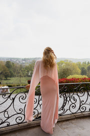 Robe longue moulante drapée portée par une femme, vue de dos, cape, balcon